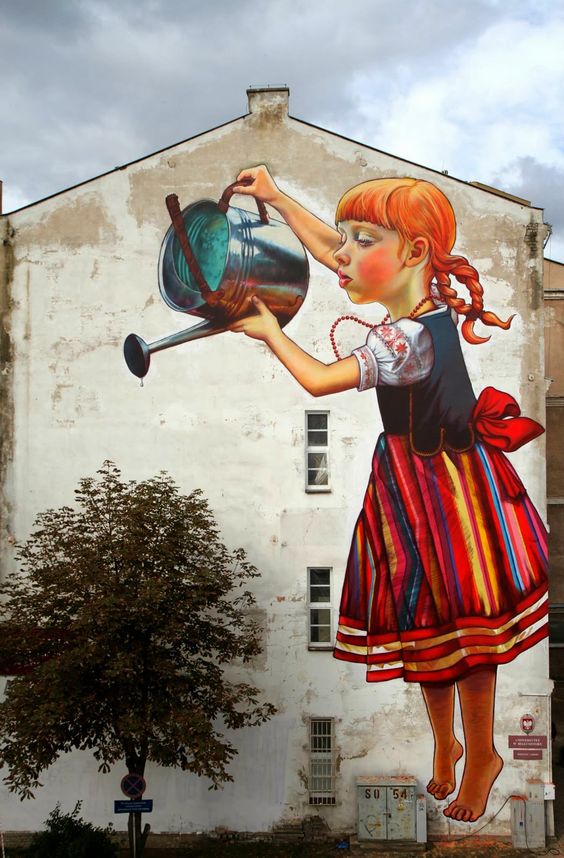 Natalia Rak recently stopped by the city of Bialystok where she worked several days on this new piece ofr the Folk On The Street Festival.The Polish Street Artist painted this stunning piece of a young girl wearing a traditional polish outfit while watering a tree.Have a closer look at the crisp mur 