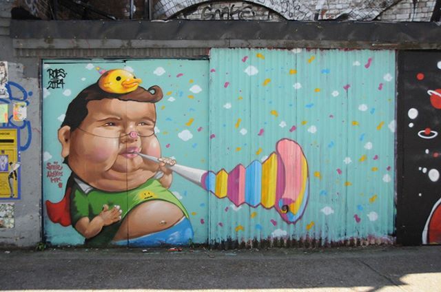 Graffiti of a Fat person blowing a party horn in Shoreditch, London